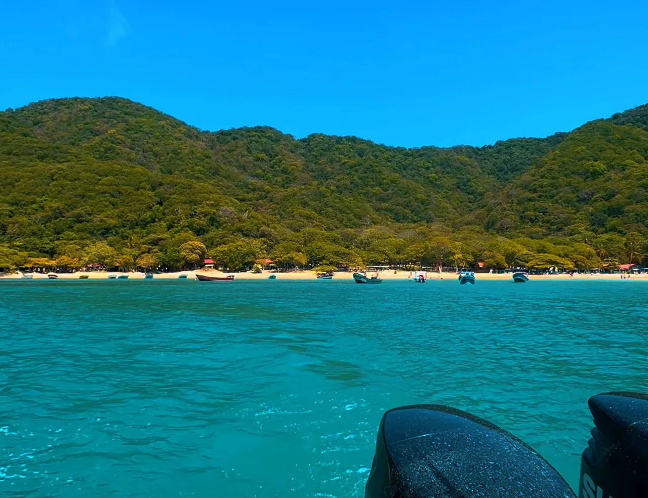 Agua turquesa y costa montañosa durante una salida a Playa Cristal.