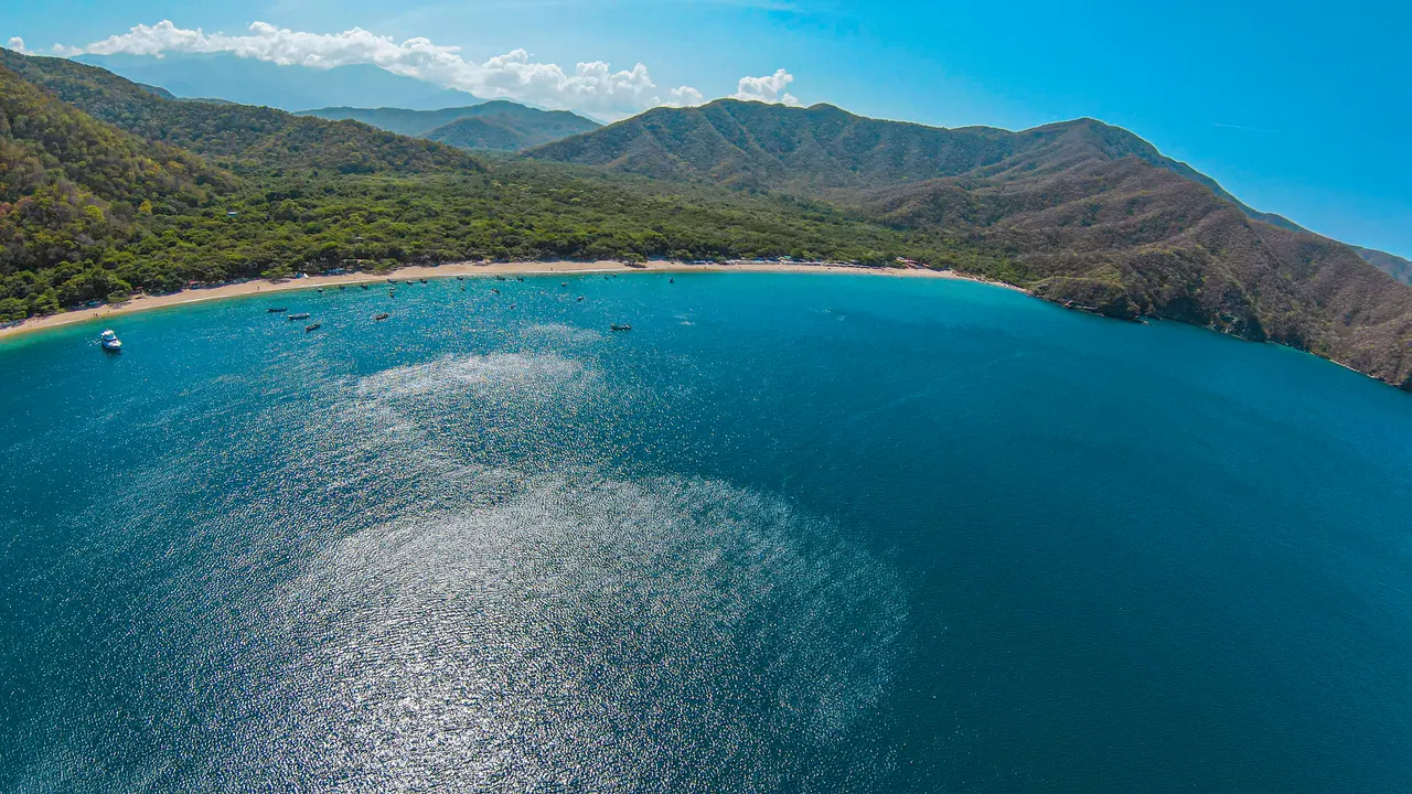 Bahía Concha, seen from the air, with the blue water and the mountains in the background.