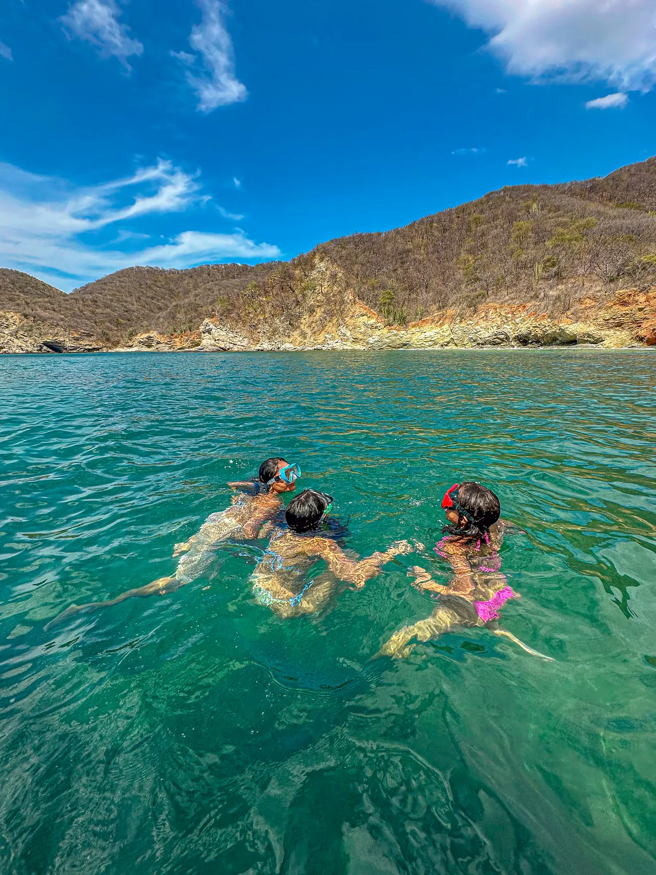 People swimming with goggles in the waters of Granate.
