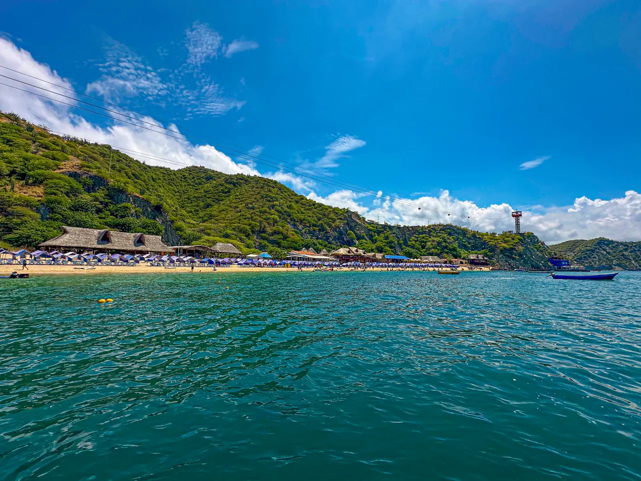 Playa Blanca, seen from the sea, with its kiosks and hills.