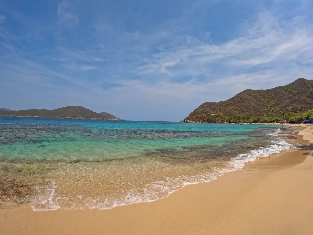 The shore at Playa Cristal, with crystal-clear water lapping at the sand.