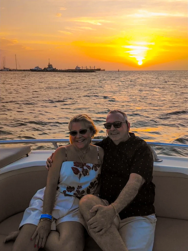 A couple enjoying the sunset aboard the boat.