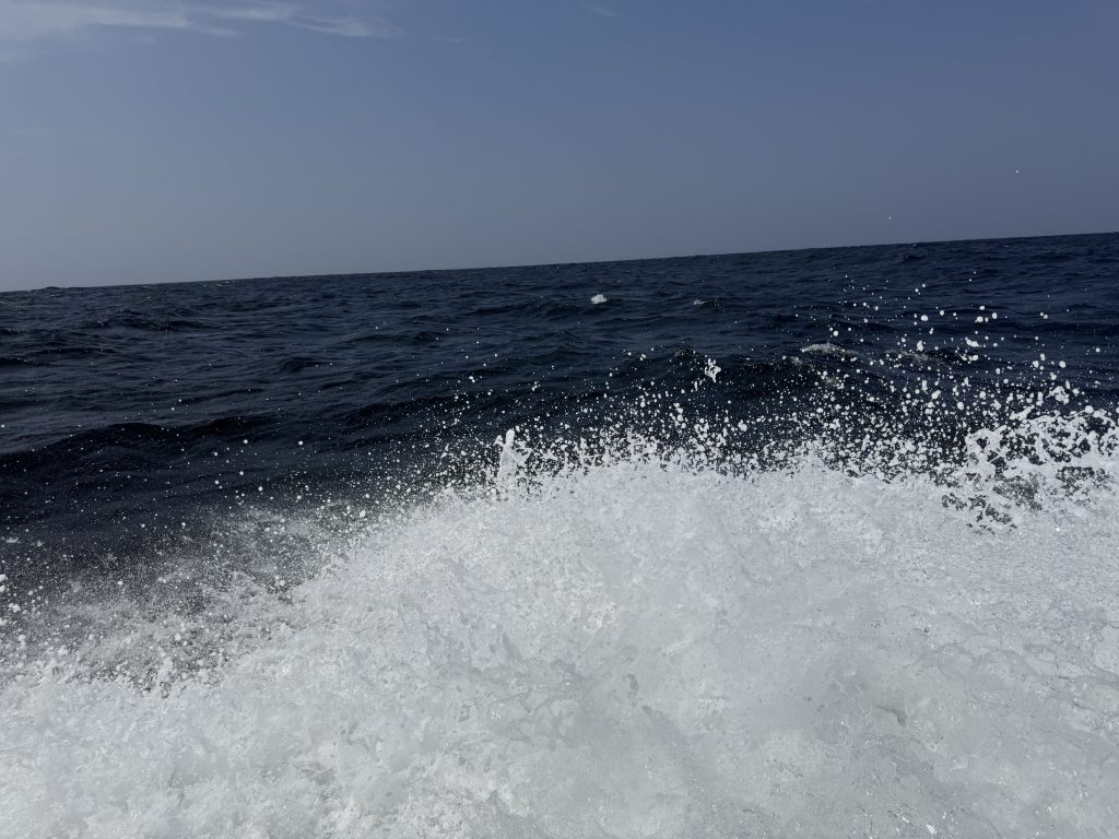 The wake of the boat on the open sea.